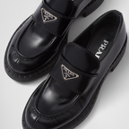 Chocolate brushed leather loafers – upper with leather strap Enameled metal triangle logo 50 mm rubber monobloc sole – LUX VERSE Luxury Designer Fashion Outlet