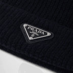 Wool and cashmere beanie – shaker knit Leather and enameled metal triangle logo Imported The model is 186 cm – LUX VERSE Luxury Designer Fashion Outlet